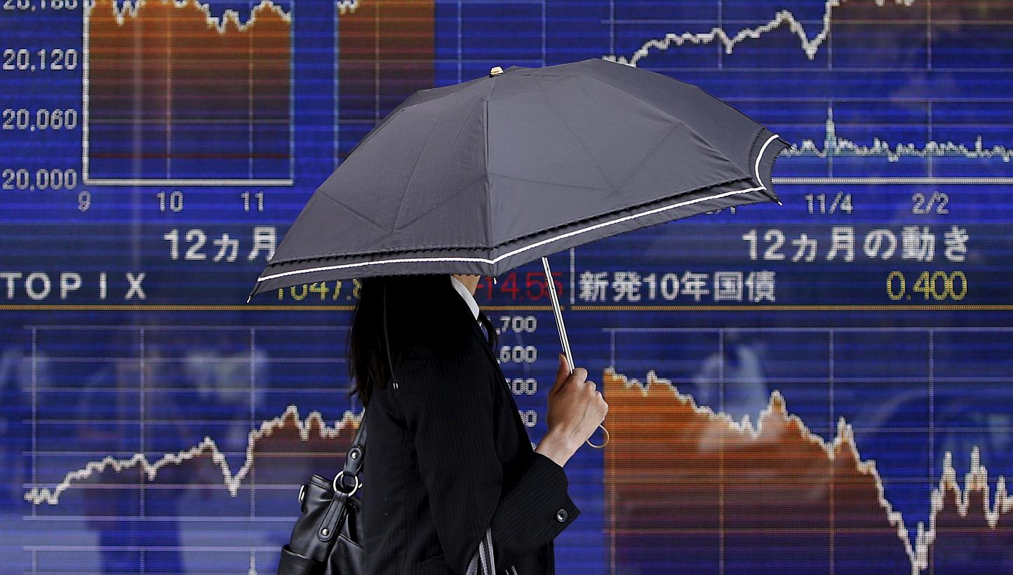 A pedestrian walking past an electronic board showing the graph of the recent fluctuations of Japan's Nikkei average outside a brokerage in Tokyo, Japan, on May 20, 2015. -- PHOTO: REUTERS&nbsp;