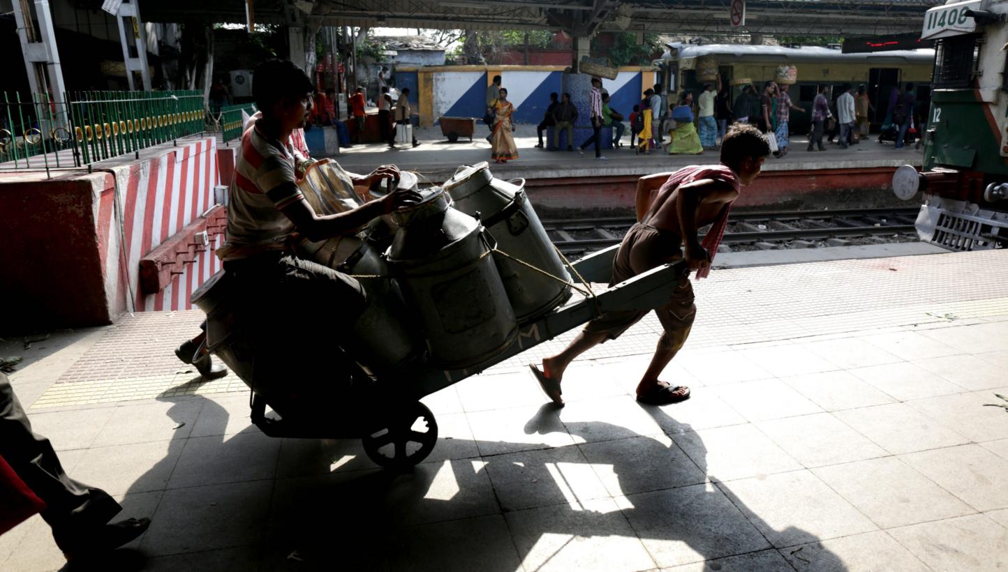 An Indian worker carrying milk containers at a railway platform in Kolkata on May 22, 2015. -- PHOTO: EPA