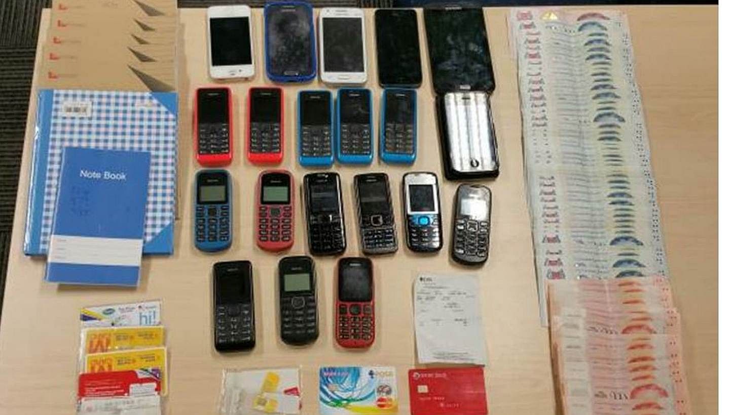 Officers seized about $6,400 in cash, mobile phones, Automated Teller Machine (ATM) cards, banking slips and bank account books. -- PHOTO: SINGAPORE POLICE FORCE