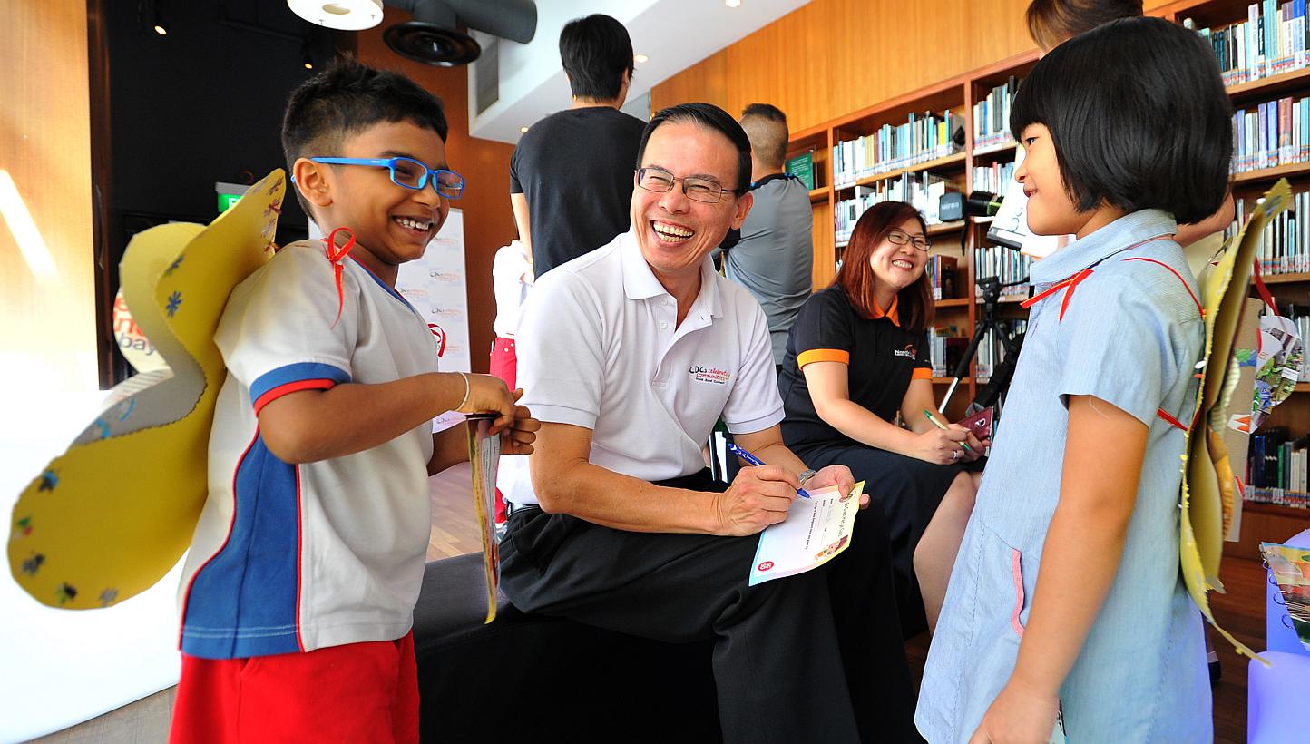 Mayor for North West CDC Dr Teo Ho Pin (centre) writing Go Green Pledge Cards with children from PCF Sparkletots Woodlands during a media preview of CDCs Celebrating Communities, a community parade and brisk walk to be held at Marina Bay this coming 