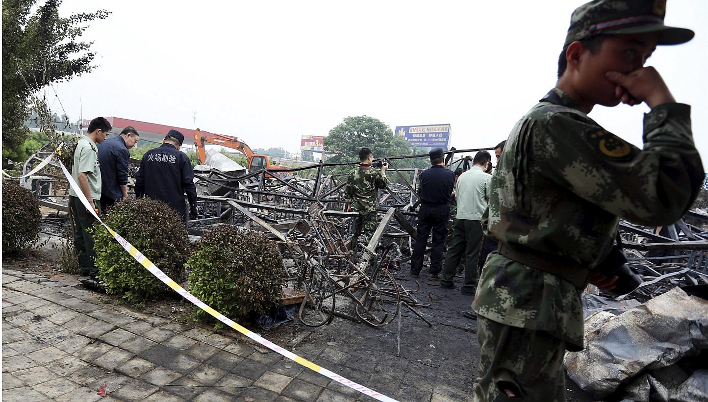 Policemen and fire inspectors work among the debris at a rehabilitation centre for elderly after a fire broke out on Monday, May 25, 2015,&nbsp;in Lushan county, Henan province, China, on Wednesday. -- PHOTO: REUTERS
