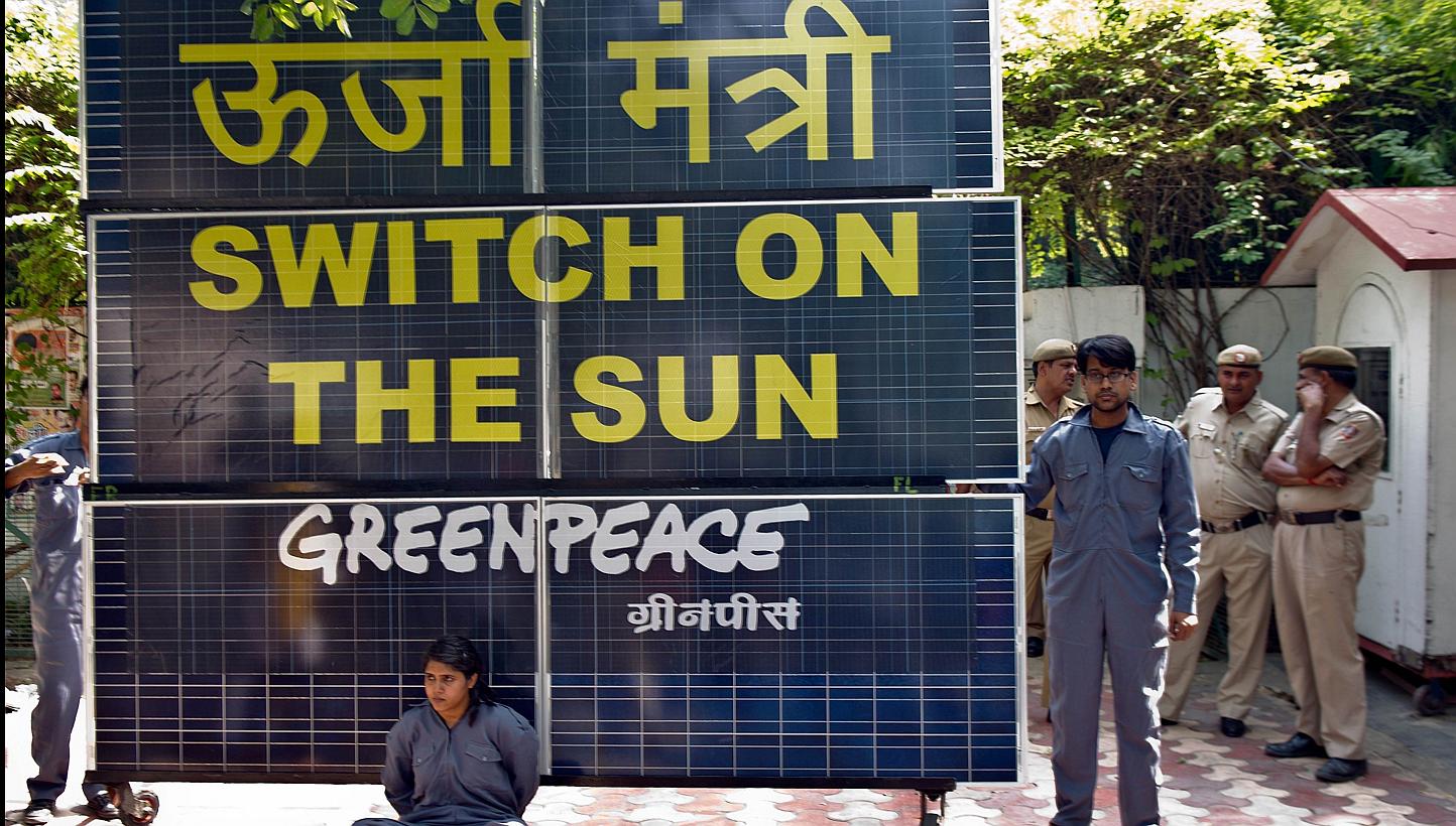 Greenpeace activists chained to a bank of solar panels blocking the entry to the residence of Delhi's then Power Minister Haroon Yusuf in New Delhi, on May 15, 2013. A court in New Delhi on Wednesday, May 27, 2015, ordered authorities to unfreeze Gre