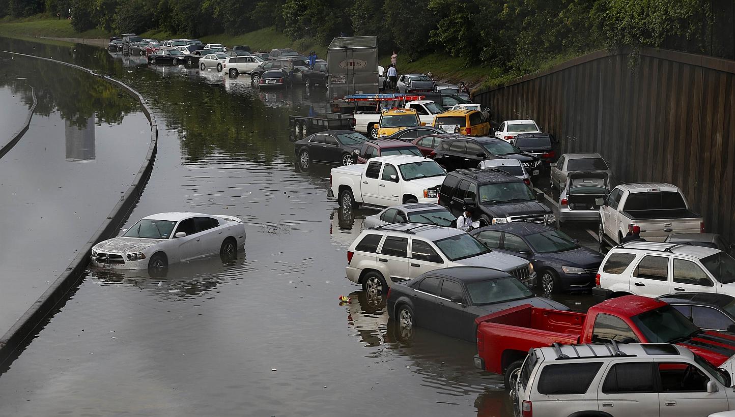 Vehicles left stranded on a flooded Interstate 45 in Houston on Tuesday. Heavy rains and flooding put the city of Houston under massive ammounts of water, closing roadways and trapping residents in their cars and buildings, -- PHOTO: AFP