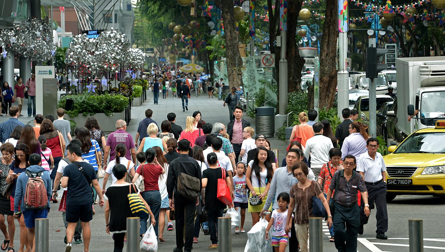 Shoppers along Orchard Road near the junction of Takashimaya. Consumer confidence in Singapore continued to climb in May, with respondents in a survey more upbeat about both their current and future financial state. -- PHOTO: ST FILE