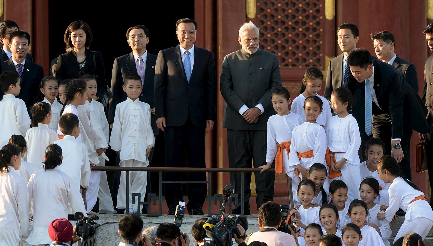 Indian Prime Minister Narendra Modi (centre, right) and Chinese Premier Li Keqiang (centre, left) pose for pictures with child performers of a taiji and yoga event, at the Temple of Heaven park in Beijing, China on May 15, 2015. -- PHOTO: AFP