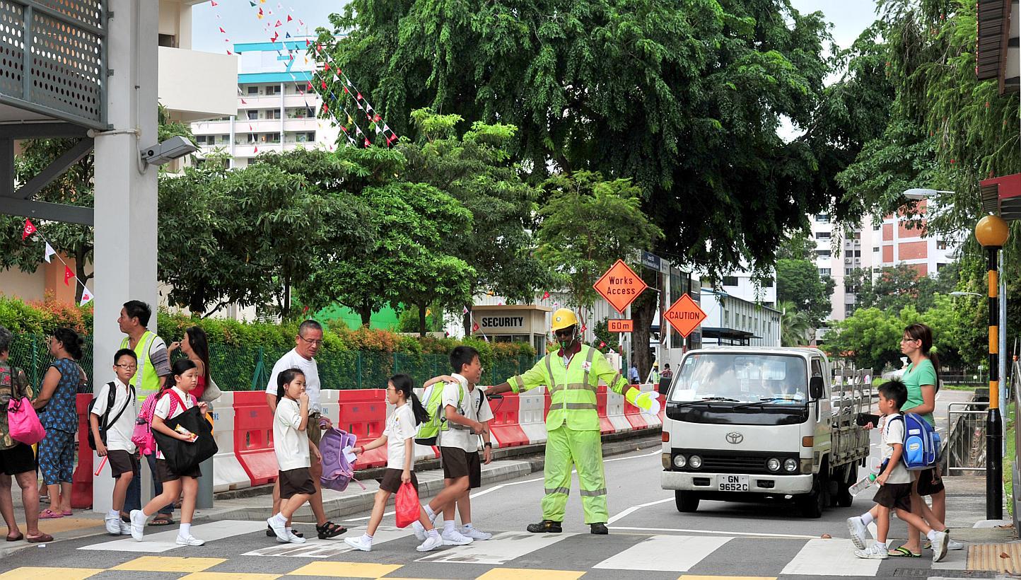 A traffic marshal guiding pupils from Hong Wen School across a zebra crossing. Sweden and the UK topped a survey of 32 countries in terms of road safety, and while Singapore was not included in the survey, data shows that it would have ranked close t
