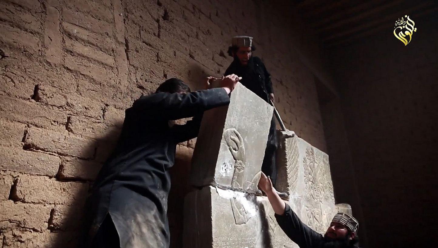An image grab taken from a video made available by Jihadist media outlet Welayat Nineveh on April 11, 2015, allegedly shows members of the Islamic State (IS) militant group destroying a stoneslab with a sledgehammer at what they said was the ancient 