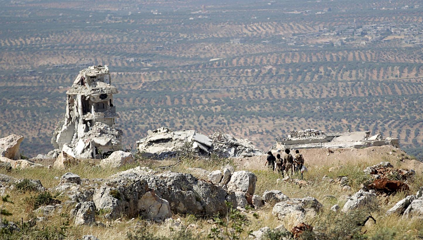 Rebel fighters from the Ahrar al-Sham Islamic Movement walking on a hill in Jabal al-Arbaeen, which overlooks the northern town of Ariha. -- PHOTO: REUTERS