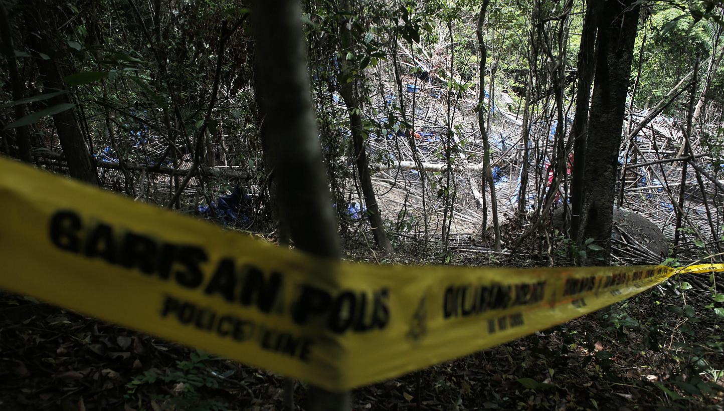 &nbsp;Police tape cordoned off the site of an abandoned camp in which graves were found at Wang Burma hills at Wang Kelian, Perlis, Malaysia, on May 26, 2015. -- PHOTO: EPA