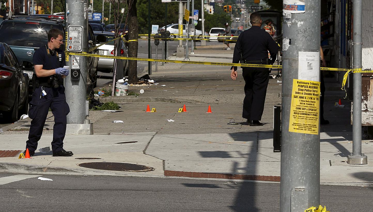 Police place evidence markers at spots where shell casings have been found at the scene of a shooting at the intersection of West North Avenue and Druid Hill Avenue in West Baltimore, Maryland on May 30, 2015. -- PHOTO: REUTERS