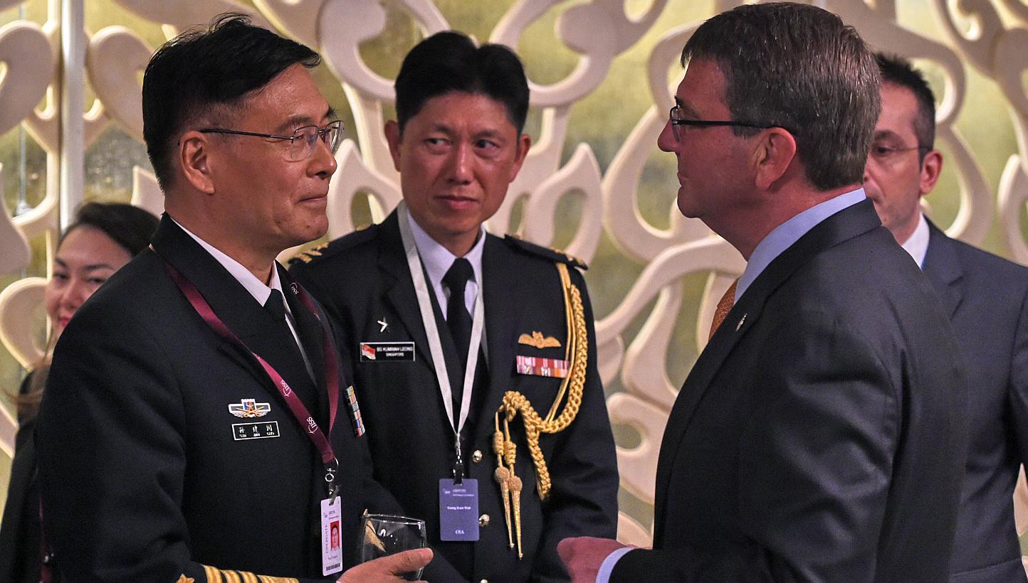 Sun Jianguo (left) from the Chinese People's Liberation Army Navy, chats with US Secretary of Defense Ashton Carter (right) during the ministerial luncheon at the 14th Asia Security Summit, the International Institute for Strategic Studies (IISS) Sha
