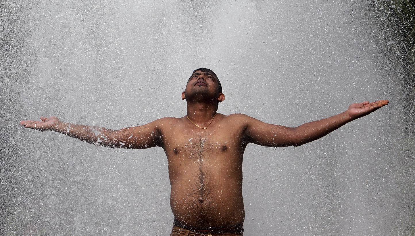 A man cools himself off at a municipal corporation water treatment plant on a hot summer day in Agartala, India, on May 31, 2015.&nbsp;Scattered rain on Sunday brought much-needed but only temporary relief to parts of India hit by a long heatwave as 