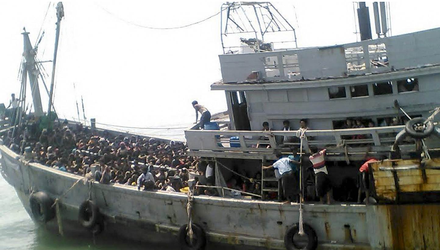 A handout picture released by the Myanmar Ministry of Information on May 30, 2015 shows migrants who were seized by the Myanmar navy in a boat near the Irrawaddy delta in Myanmar, on May 29, 2015.&nbsp;Myanmar's navy briefly detained and turned back 