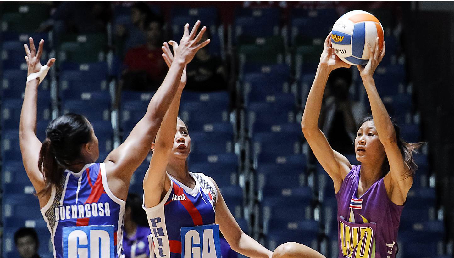 Remia Benacosa (left) and Ana Cenarosa (centre) of the Philippines defending against Thailand's Paweena Khamwan during their SEA Games netball match on Sunday, May 31, 2015. -- PHOTO: REUTERS 