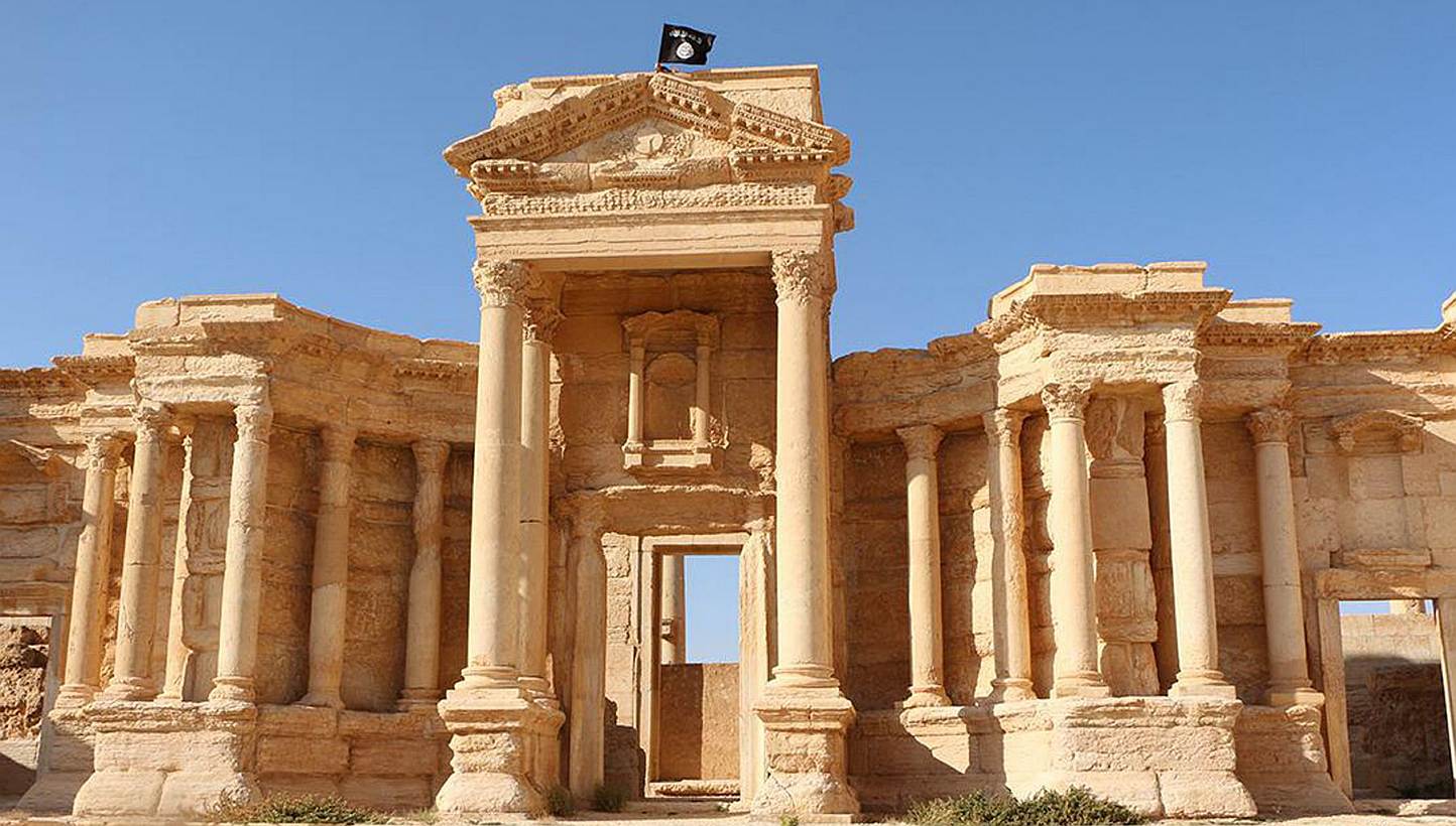 An image made available by Jihadist media outlet Welayat Homs on May 28, 2015 allegedly shows a flag of the Islamic State in Iraq and Syria (ISIS) on the circular wall bounding the Roman theatre of the ancient city of Palmyra.&nbsp;The anti-ISIS coal