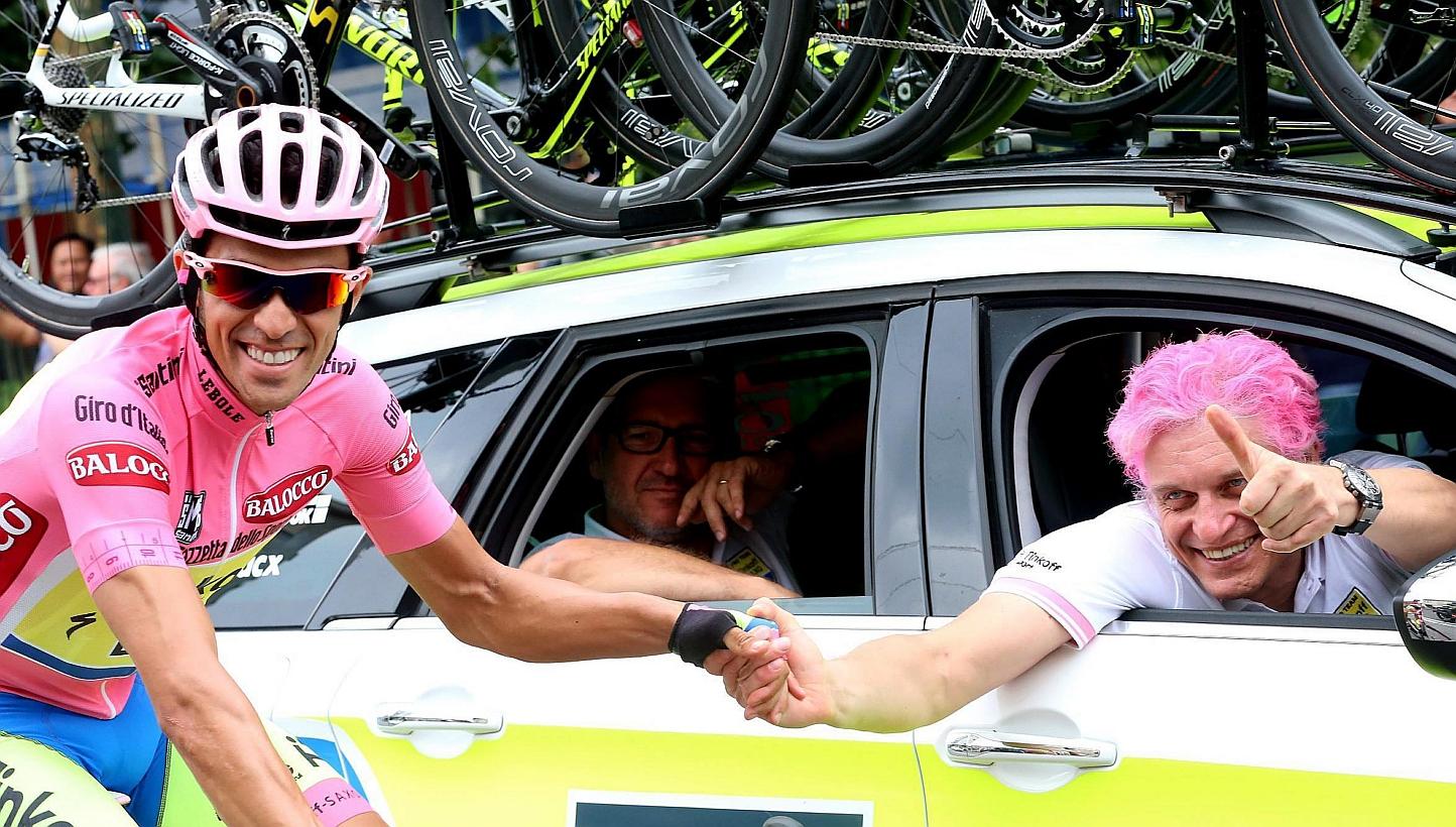 Spanish rider Alberto Contador (left) of the Tinkoff-Saxo team and Russian businessman and team owner Oleg Tinkov, &nbsp;with his hair painted in pink to match the overall leader's jersey,&nbsp;on the way to the 21st and last stage of the 98th Giro d