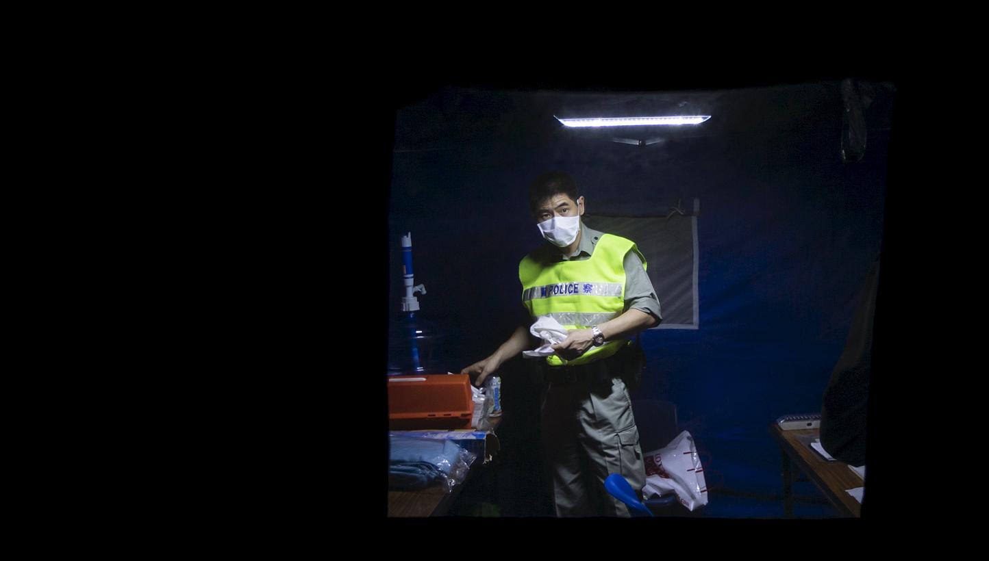 A police with mask stands guard outside Lady MacLehose Holiday Village in Sai Kung, where people who came into close contact with the South Korean MERS patient will spend two weeks in quarantine, in Hong Kong, China, on May 29, 2015. -- PHOTO: REUTER