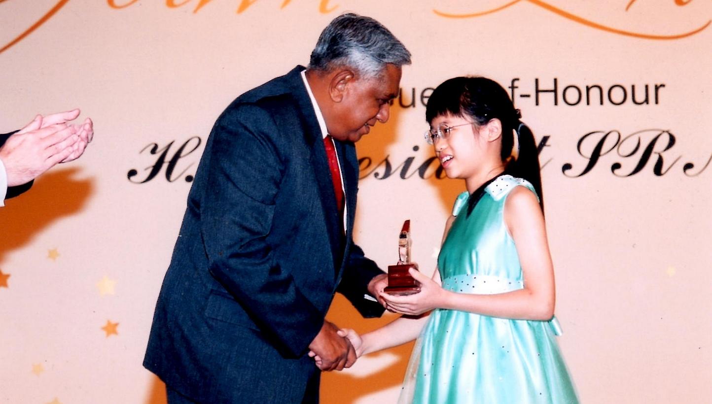 Abigail Sin at age four with her twin Josiah, younger brother David and father Sin Lye Kuen. Abigail Sin at age 11, receiving the HSBC Youth Excellence Award from then President S R Nathan. Abigail Sin at age eight in Methodist Girls' School.