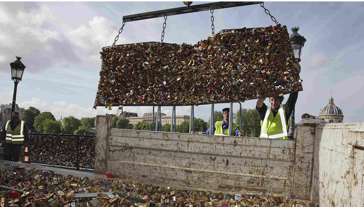 City municipal employees lower iron grills covered with "love locks" into a truck after they were removed from the Pont des Arts in Paris, France, on June 1, 2015. Parisian authorities on Monday removed tens of thousands of "love locks", padlocks cha