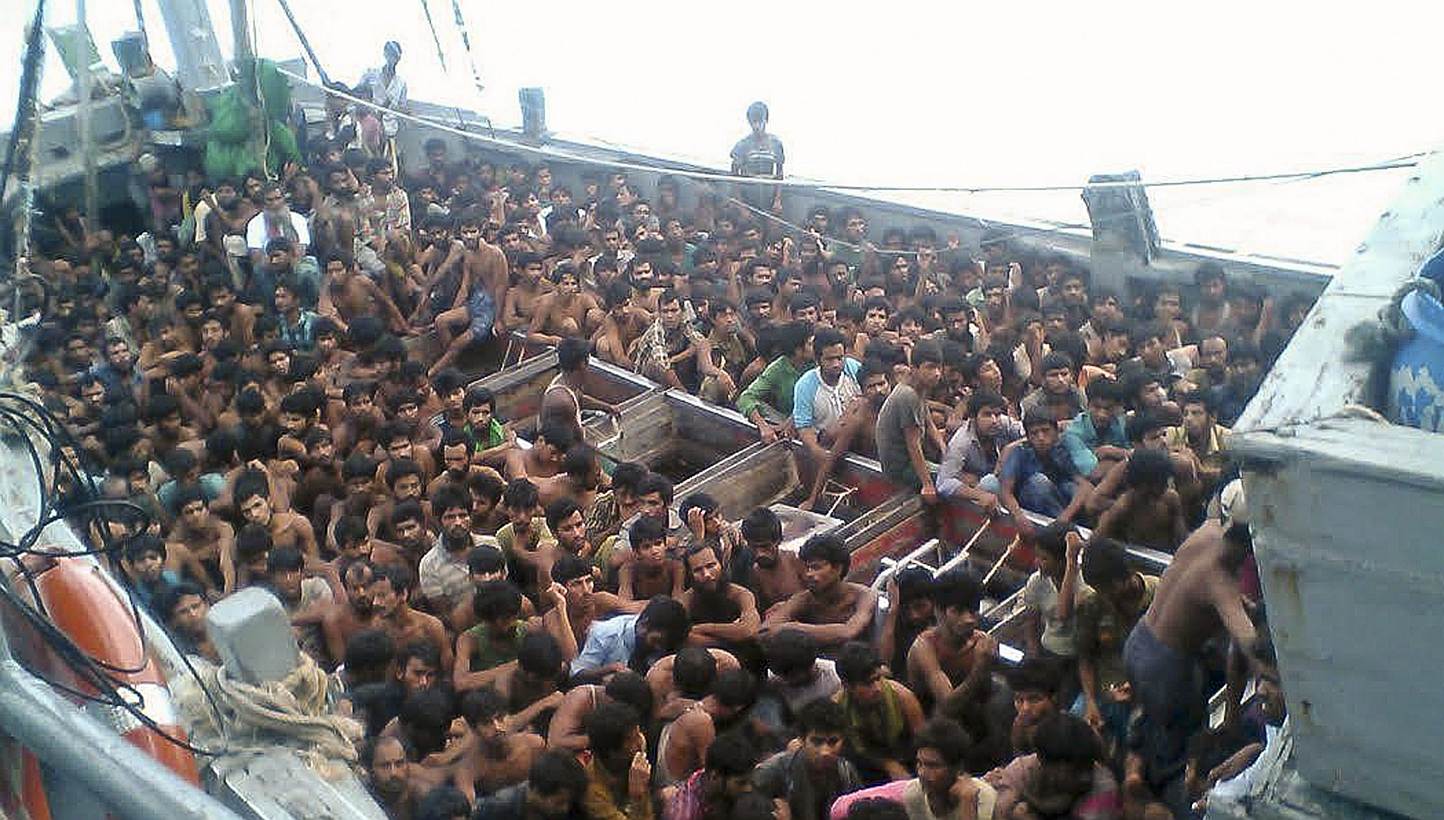 A handout picture released by the Myanmar Ministry of Information on May 30, 2015 shows migrants who were seized by the Myanmar navy in a boat near the Irrawaddy delta on May 29, 2015. The migrants were still being held offshore by Myanmar's nav