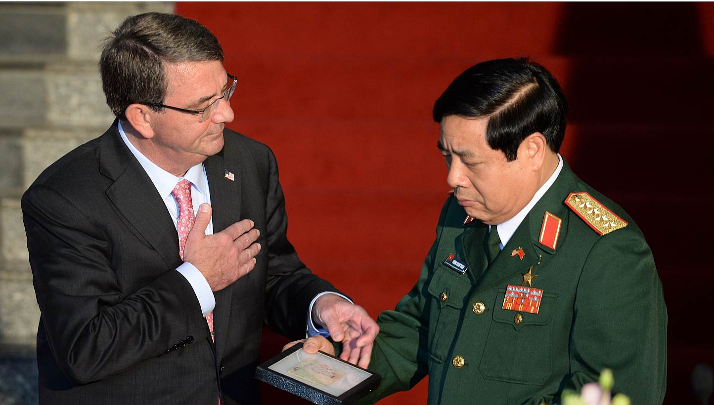 US Defense Secretary Ashton Carter (left) hands over to Vietnamese Defense Minister General Phung Quang Thanh a diary and a belt belonging to Vietnamese communist soldiers combating in the Vietnam War during a joint press conference at the Ministry o