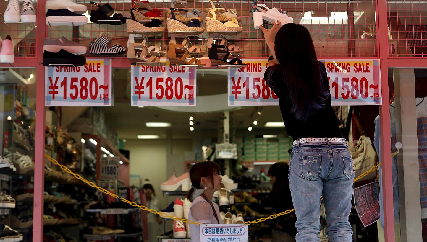 A worker preparing to open a shoe store in Tokyo's Harajuku shopping district on April 30, 2015. Japan's inflation-adjusted real wages in April turned positive for the first time in two years, adding steam to Tokyo's hope that higher pay will spur co