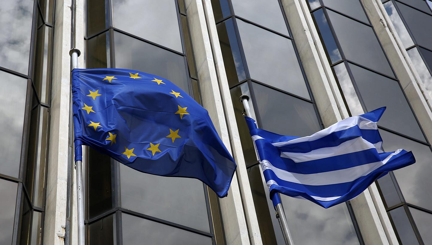 A Greek and an EU flag flutter outside the Foreign Ministry in Athens on March 12, 2015. -- PHOTO: REUTERS