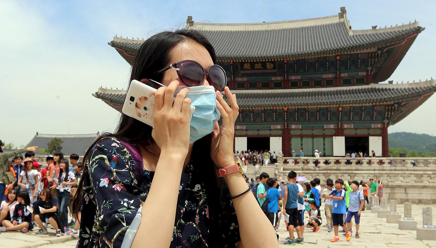 A Chinese tourist wearing a mask to prevent contracting Middle East Respiratory Syndrome (MERS) tours the Gyeongbok Palace in Seoul, South Korea, on June 1, 2015. -- PHOTO: REUTERS&nbsp;