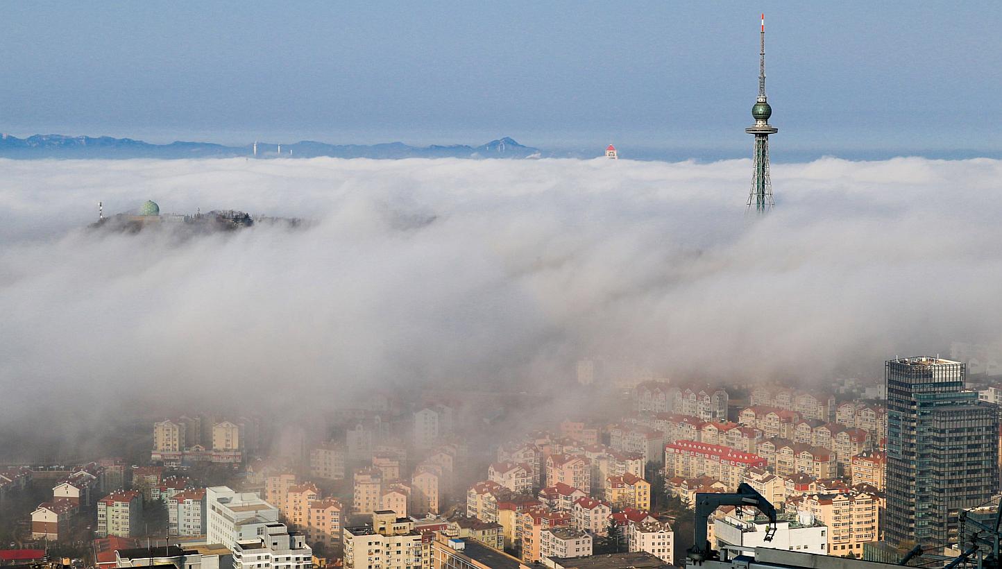 Residential buildings are seen among fog in Qingdao, Shandong province. China's housing sales in major cities, measured by floor space, jumped 37.4 per cent in May from a year earlier, a private survey showed on Tuesday, helped by government's stimul