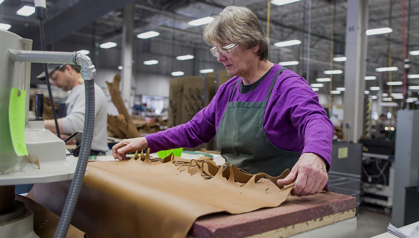 A worker using a die-cutting machine to cut out shapes of leather to be sewn into boots at the L.L. Bean manufacturing facility in Brunswick, Maine, US. -- PHOTO: BLOOMBERG&nbsp;