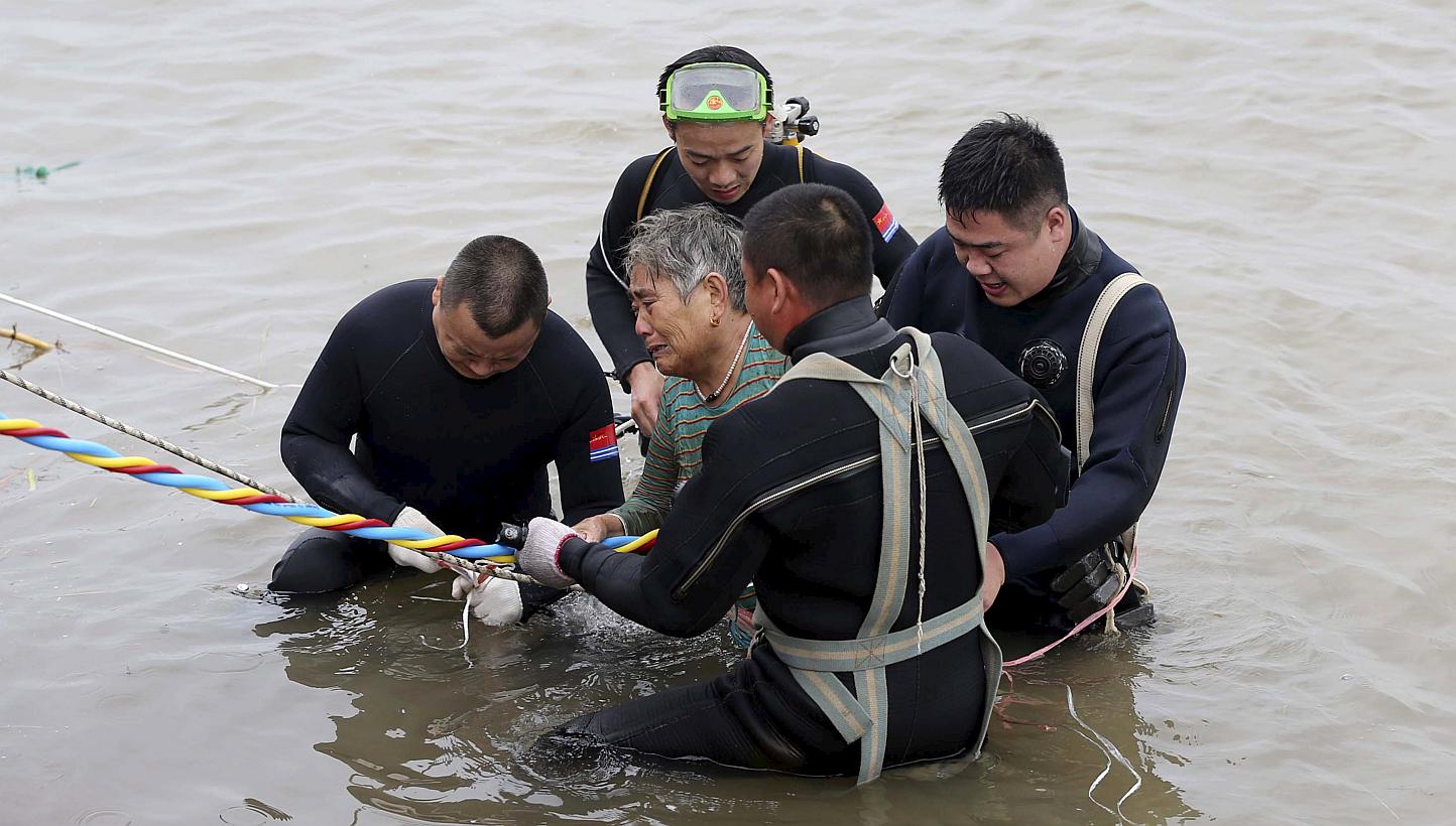 A woman is helped after being pulled out by divers from a capsized ship in Jianli, Hubei province, China on June 2, 2015. Rescuers are working to save five more passengers trapped inside the hull of the ship that capsized in China's Yangtze River&nbs