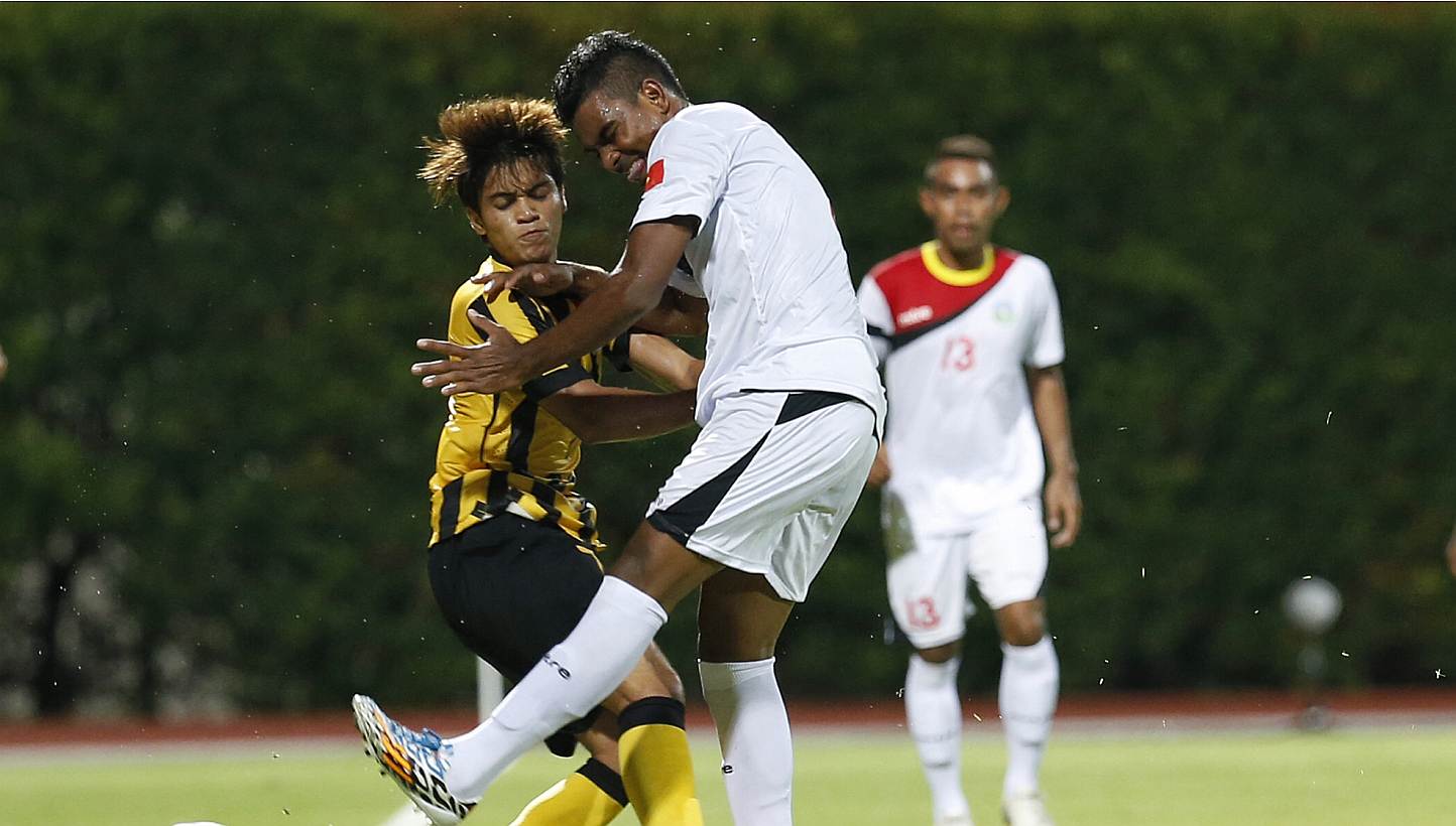 Malaysia's Muhammad Nazmi Faiz Mansor (left) collides with Timor Leste's Filipe Oliveira during one of their few notable altercations in the 28th SEA Games men's football first round group B match at the Bishan Stadium on May 30, 2015. Nazmi has