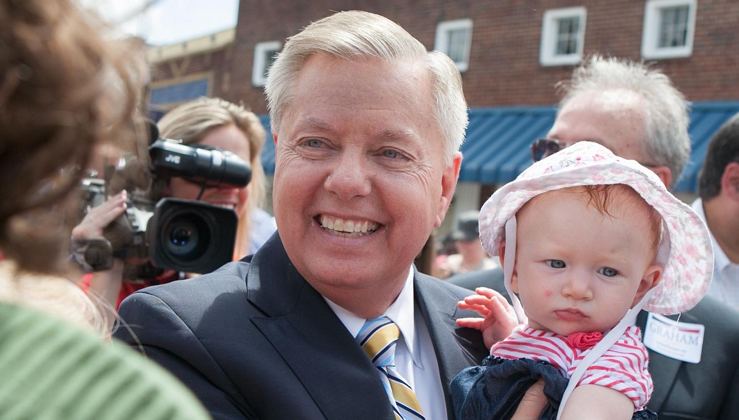 US Senator Lindsey Graham. a Republican representing South Carolina, holds a supporter's baby after announcing his candidacy for United States President during an outdoor event on June 1 in his home state. -- PHOTO: AFP