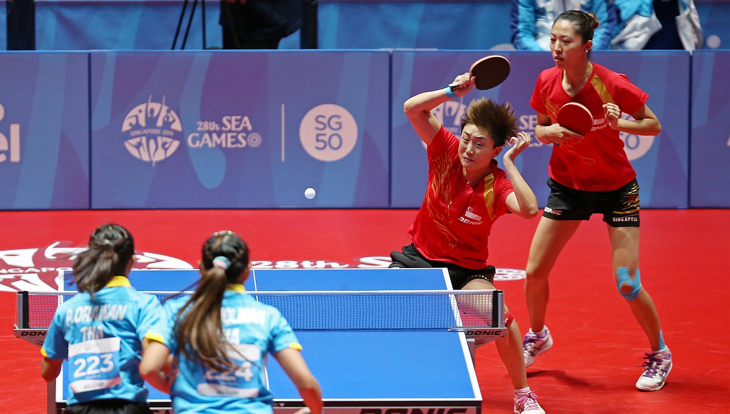 Singapore paddlers Yu Mengyu (far right) and Feng Tianwei in action against Thailand in the SEA Games women's doubles quarter-finals at the Singapore Indoor Stadium on June 1, 2015. -- ST PHOTO: SEAH KWANG PENG