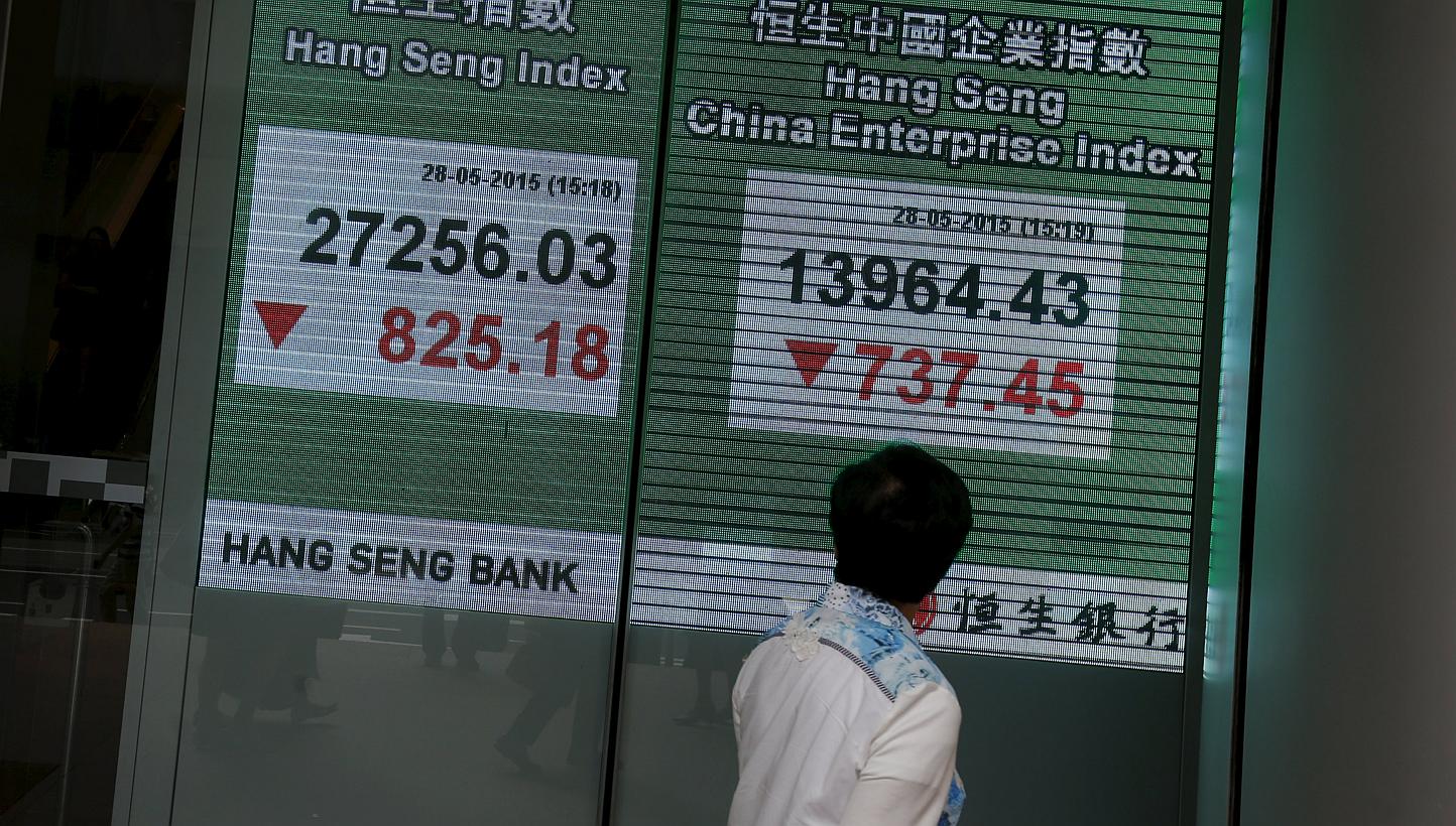 A passerby looking at a panel displaying the blue-chip Hang Seng Index outside a bank during afternoon trading in Hong Kong, China on May 28, 2015. -- PHOTO: REUTERS