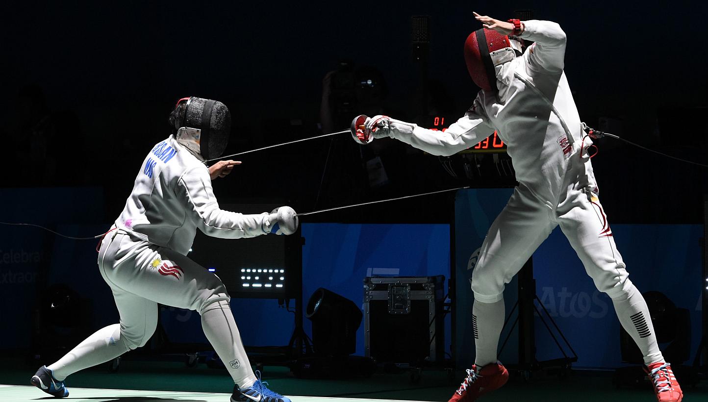 Malaysia's Mohamad Roslan Mohamed (left) competes with Singapore's Lim Wei Wen (right) in their men's individual epee round of 16 fencing match during the 28th Southeast Asian Games (SEA Games) in Singapore on June 3, 2015. -- PHOTO: AFP