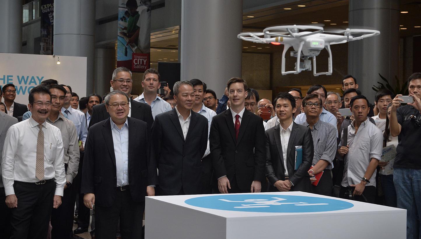 A drone ascending as it prepares to take a picture of guests during the launch of the Urban Redevelopment Authority (URA) exhibition showcasing drone applications at the URA building on May 21, 2015. -- ST PHOTO: MARK CHEONG 