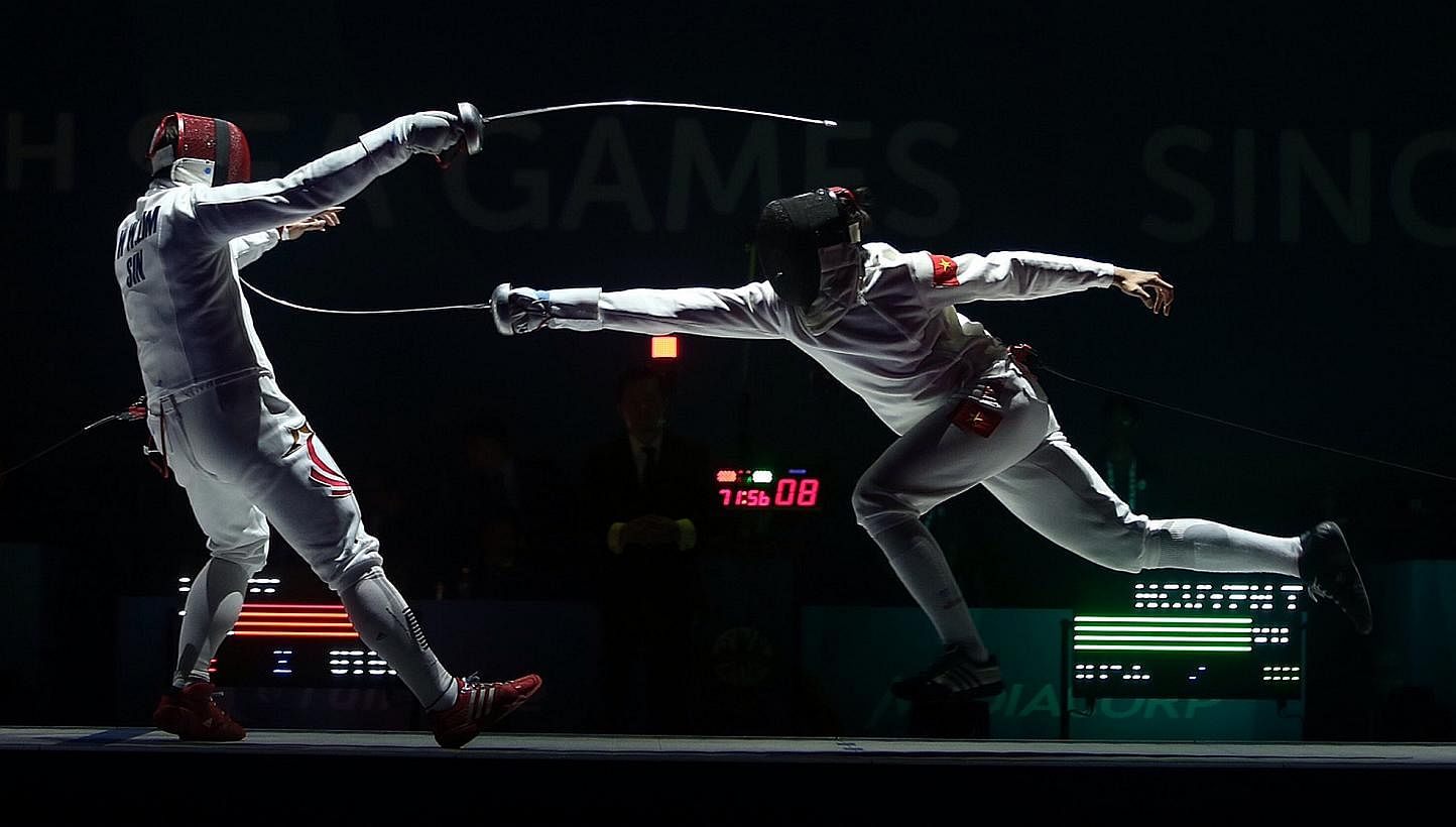 Vietnam's Nguyen Tien Nhat (right) beats Singapore's Lim Wei Wen (left) 15-8 during the finals of the Men's individual épée match held at the OCBC Arena Hall 2 on June 3, 2015. -- ST PHOTO: NEO XIAOBIN&nbsp;