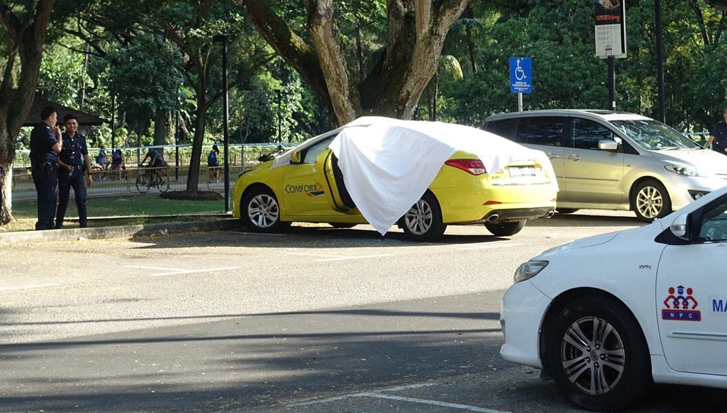 Police officers standing near a taxi where a cabbie was found dead, along East Coast Road, on Wednesday, June 3, 2015. -- ST PHOTO: STEPHANIE YEOW 