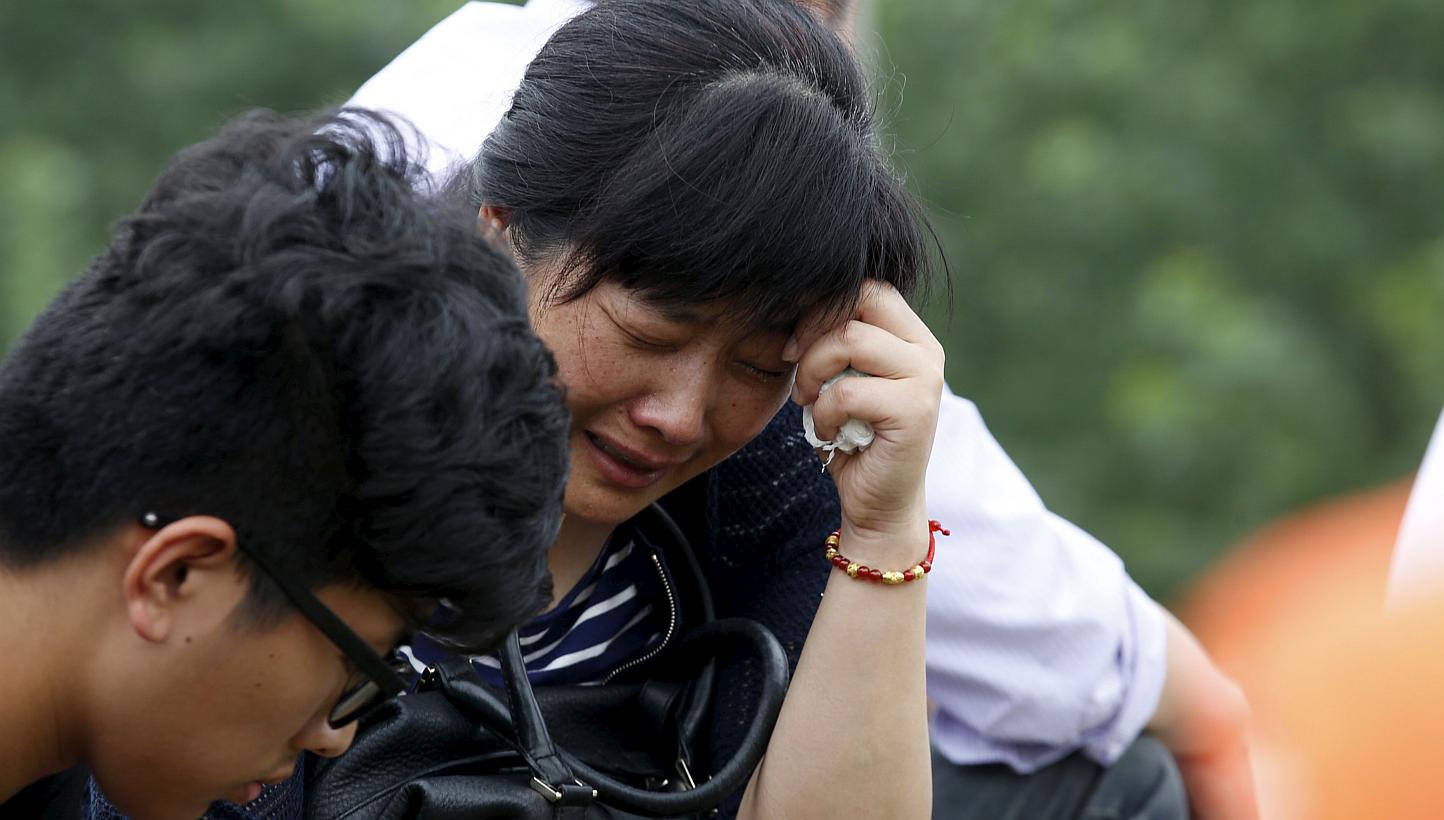 A relative of a passenger of the sunken cruise ship cries on a road to the site of the sinking in the Jianli section of Yangtze River, Hubei province, China, on June 3, 2015. More than 200 divers combed a capsized Chinese ship in the Yangtze Riv