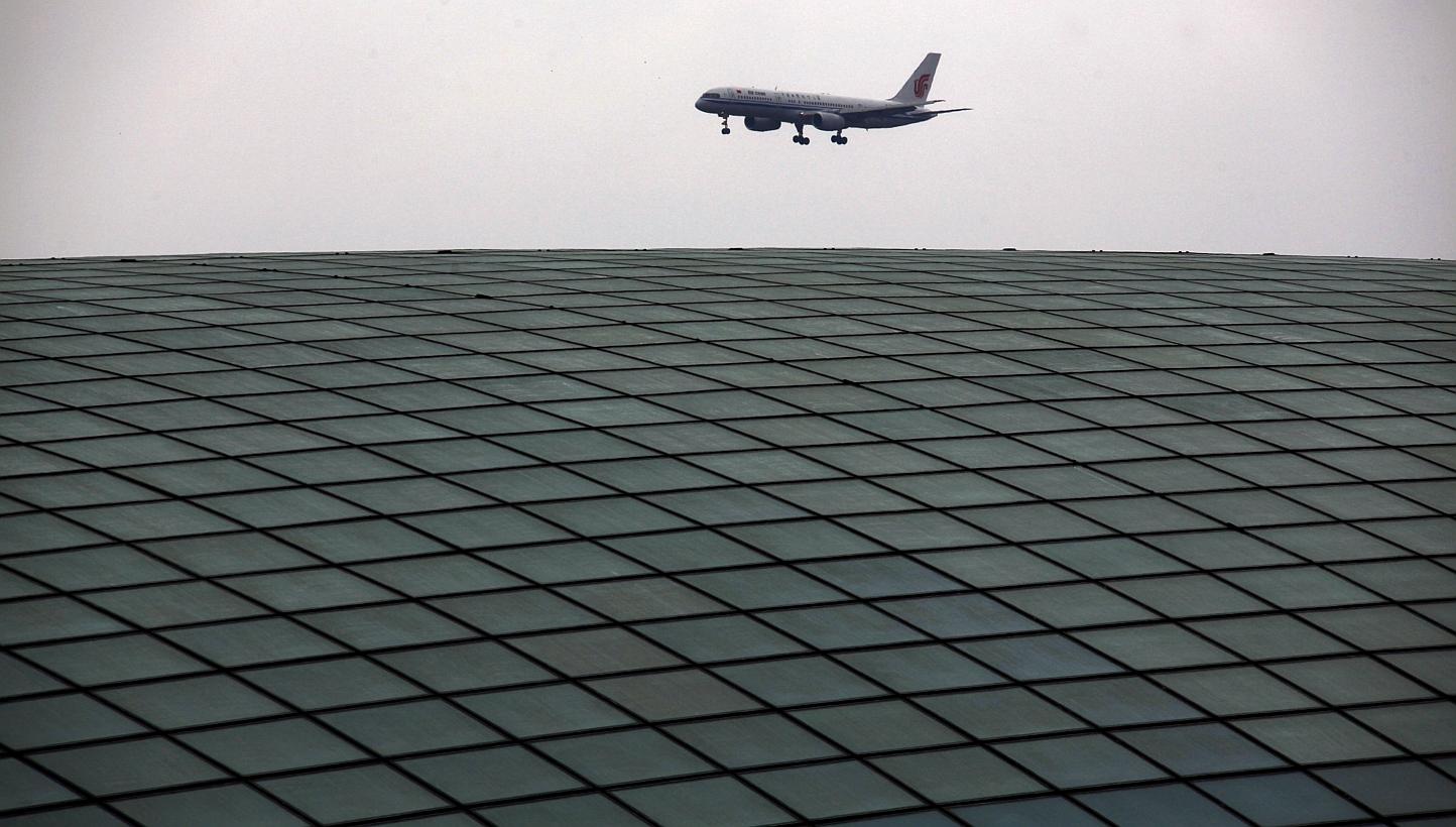 An Air China plane comes in to land over the roof of the railway station at Beijing's internationl airport in this April 21, 2011 file photo. -- PHOTO: REUTERS
