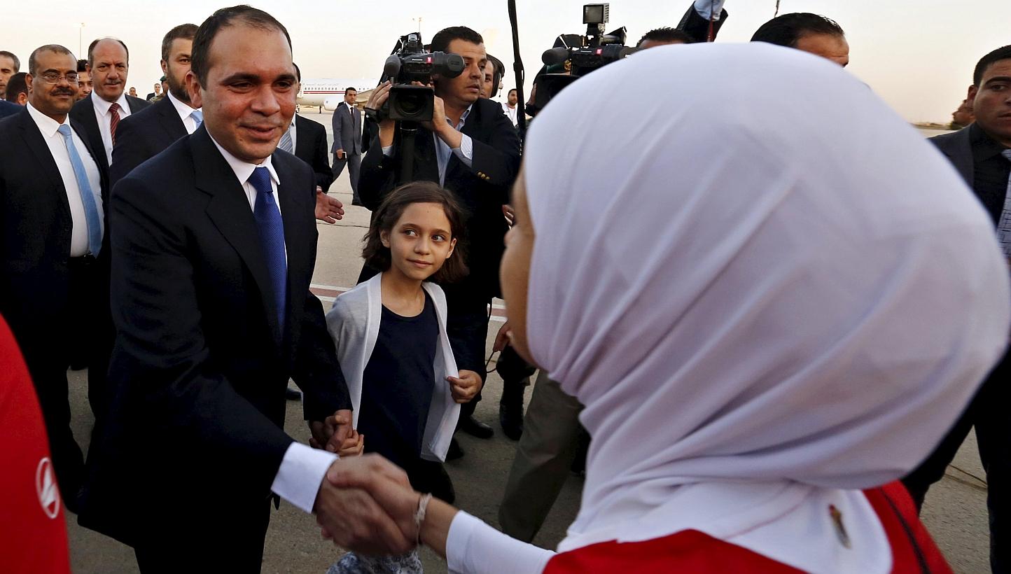 Members of the Jordanian women's national soccer team welcome Jordan's Prince Ali bin Al Hussein (left), upon his arrival at Queen Alia International Airport in Amman, after his return from participating in the International Federation of Association