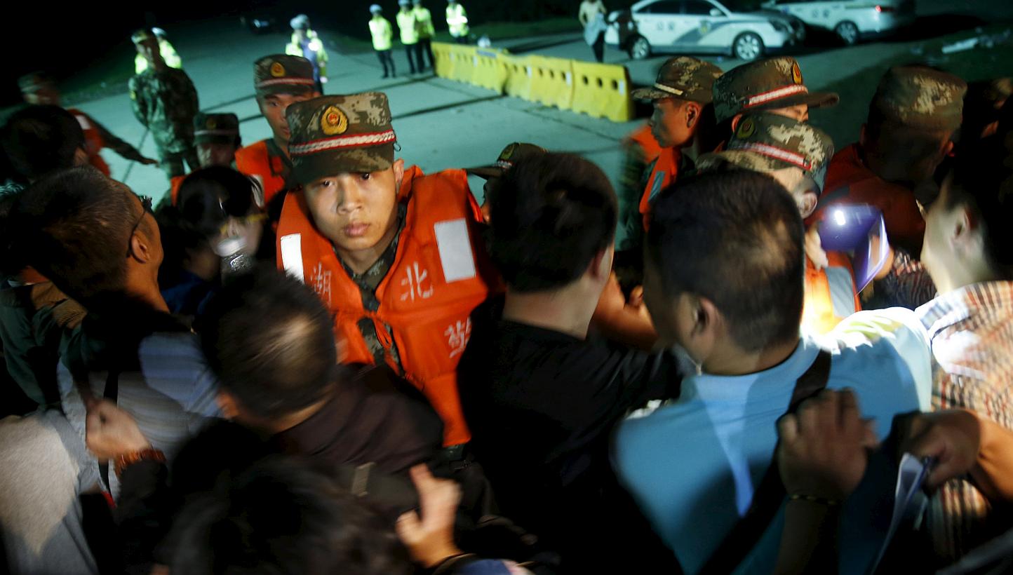 Family members of passengers of a sunken cruise ship push a cordon of paramilitary police as they march toward the site of the sunken ship in the Jianli section of Yangtze River, Hubei province, China, on June 3, 2015. -- PHOTO: REUTERS