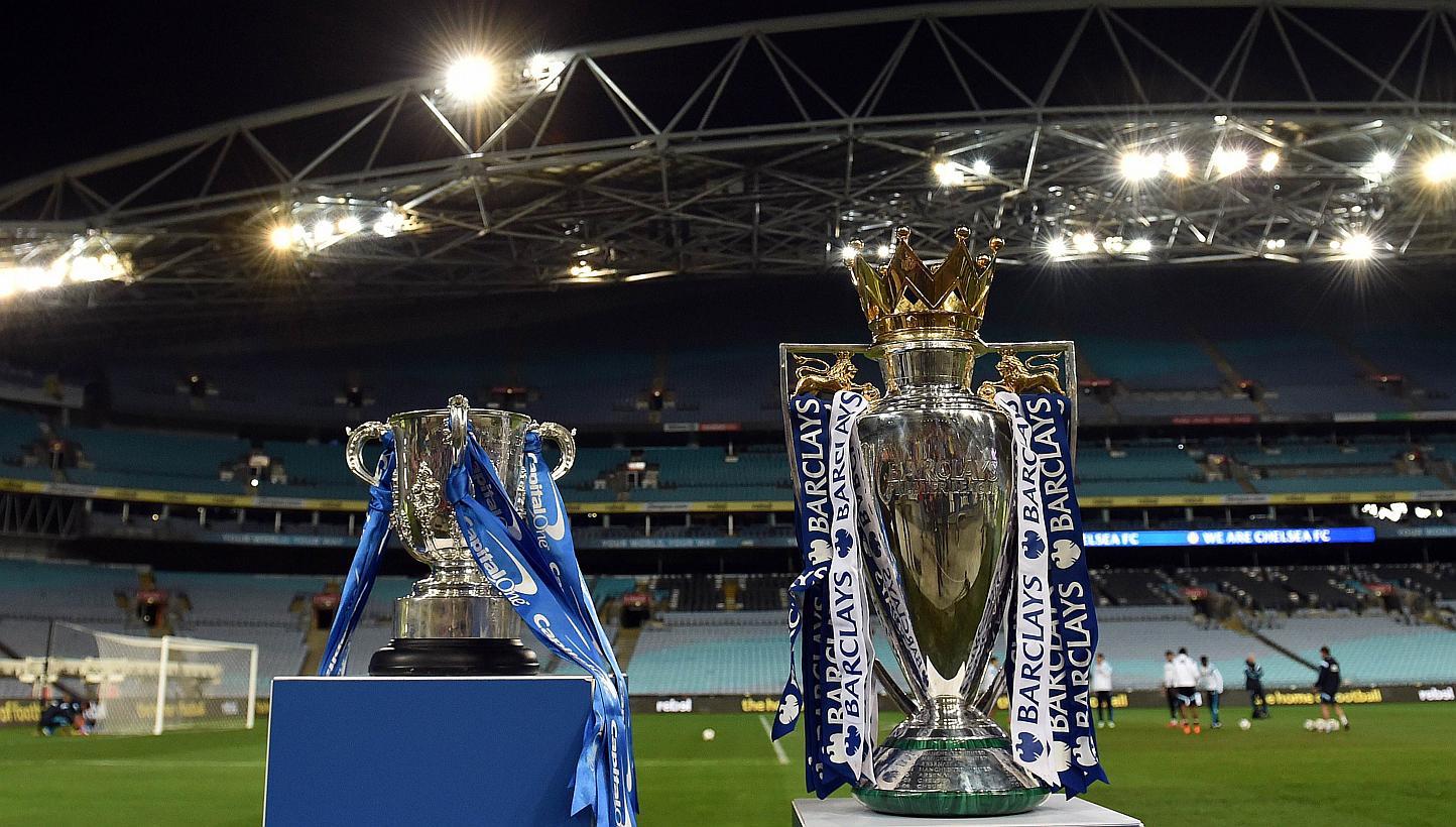 The Capital One cup (left) and English Premier League trophy are displayed as players from Chelsea take part in a football training session in Sydney on June 1, 2015. English Premier League clubs generated record combined revenues of £3.26 billion (
