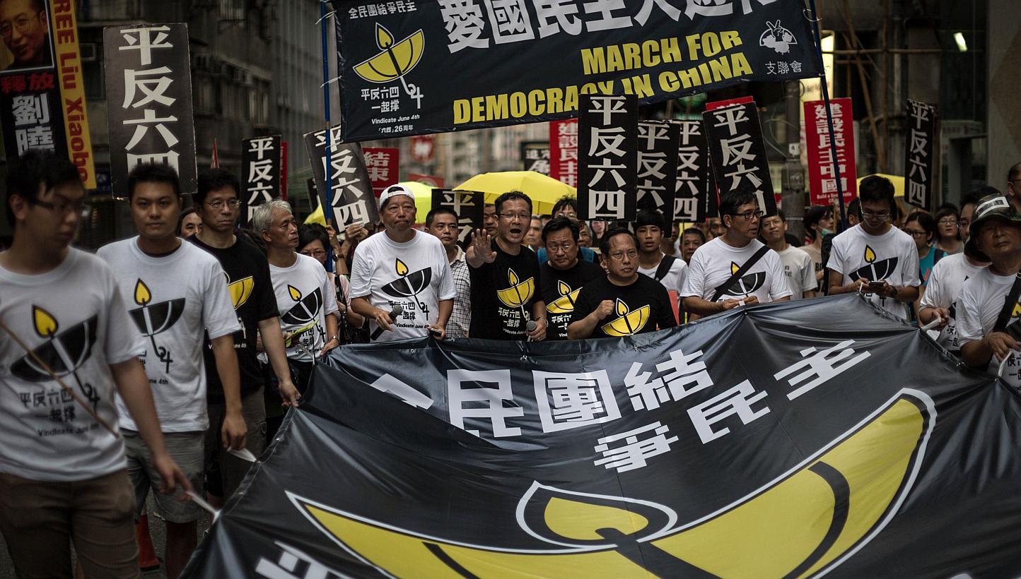 Members of the pro-democracy movement hold a huge banner as they attend a rally in Hong Kong on May 31, 2015, to commemorate the 1989 crackdown at Tiananmen Square in Beijing, prior to the incident's 26th anniversary on June 4. -- PHOTO: AFP