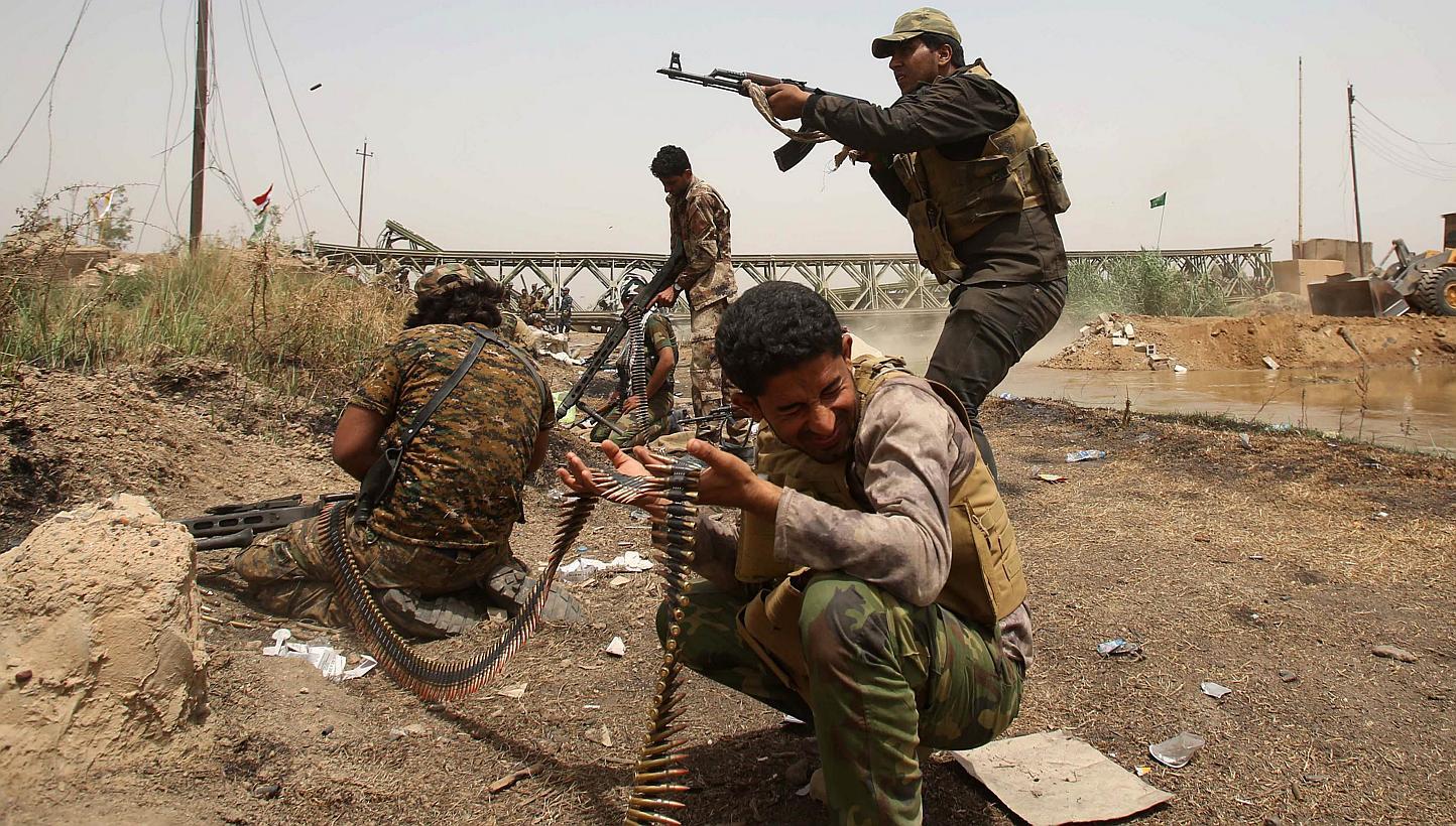 Members of the Popular Mobilisation units opens fire during a fight with ISIS militants in the area of Sayed Ghareeb, near Dujail, some 70km north of Baghdad, on May 28, 2015. -- PHOTO: AFP