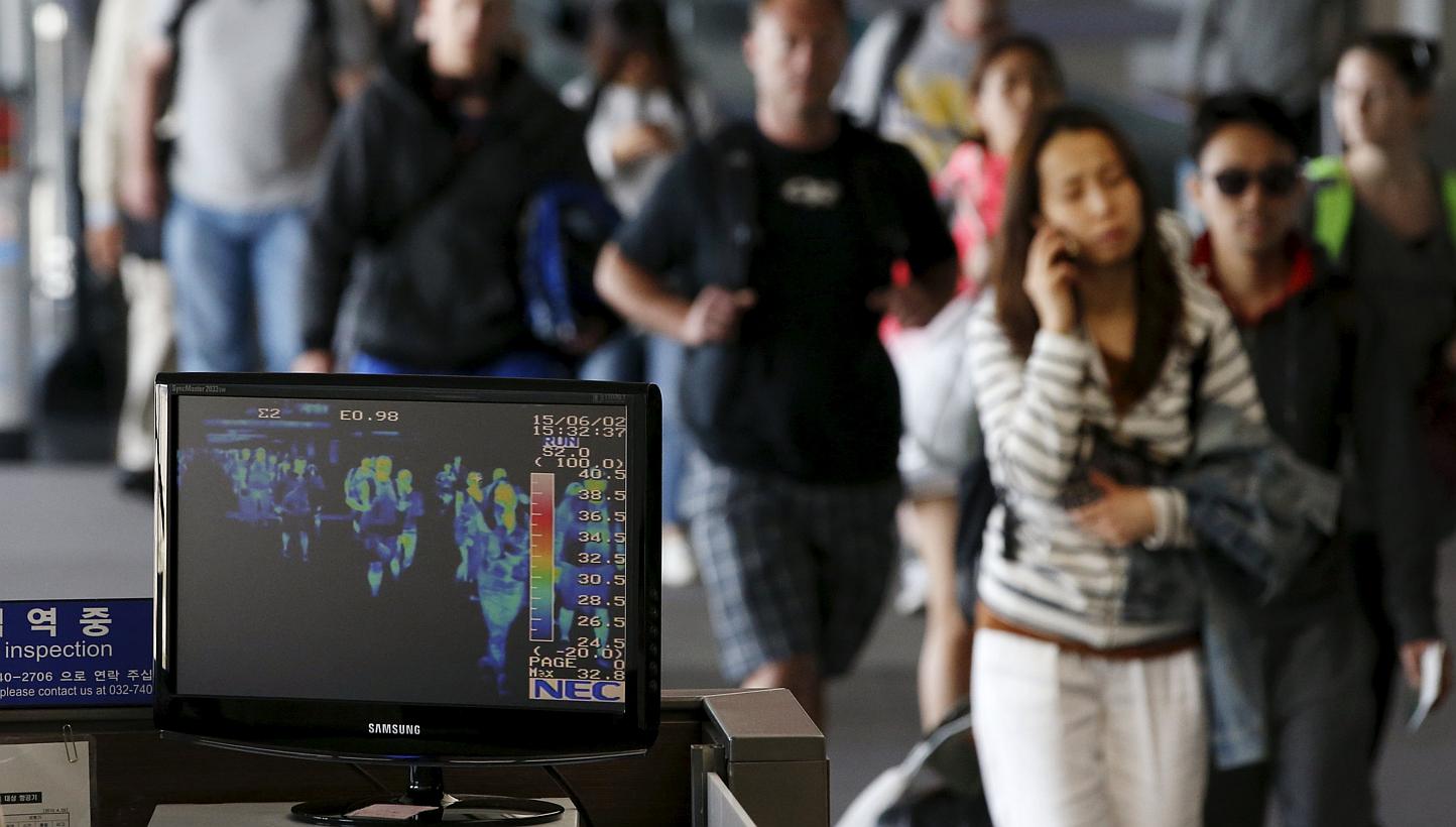 Passengers wearing masks walking past a thermal imaging camera at Incheon International Airport on June 2, 2015. South Korea said on Thursday that it had agreed to a request from North Korea to install the cameras in the Kaesong joint industrial zone