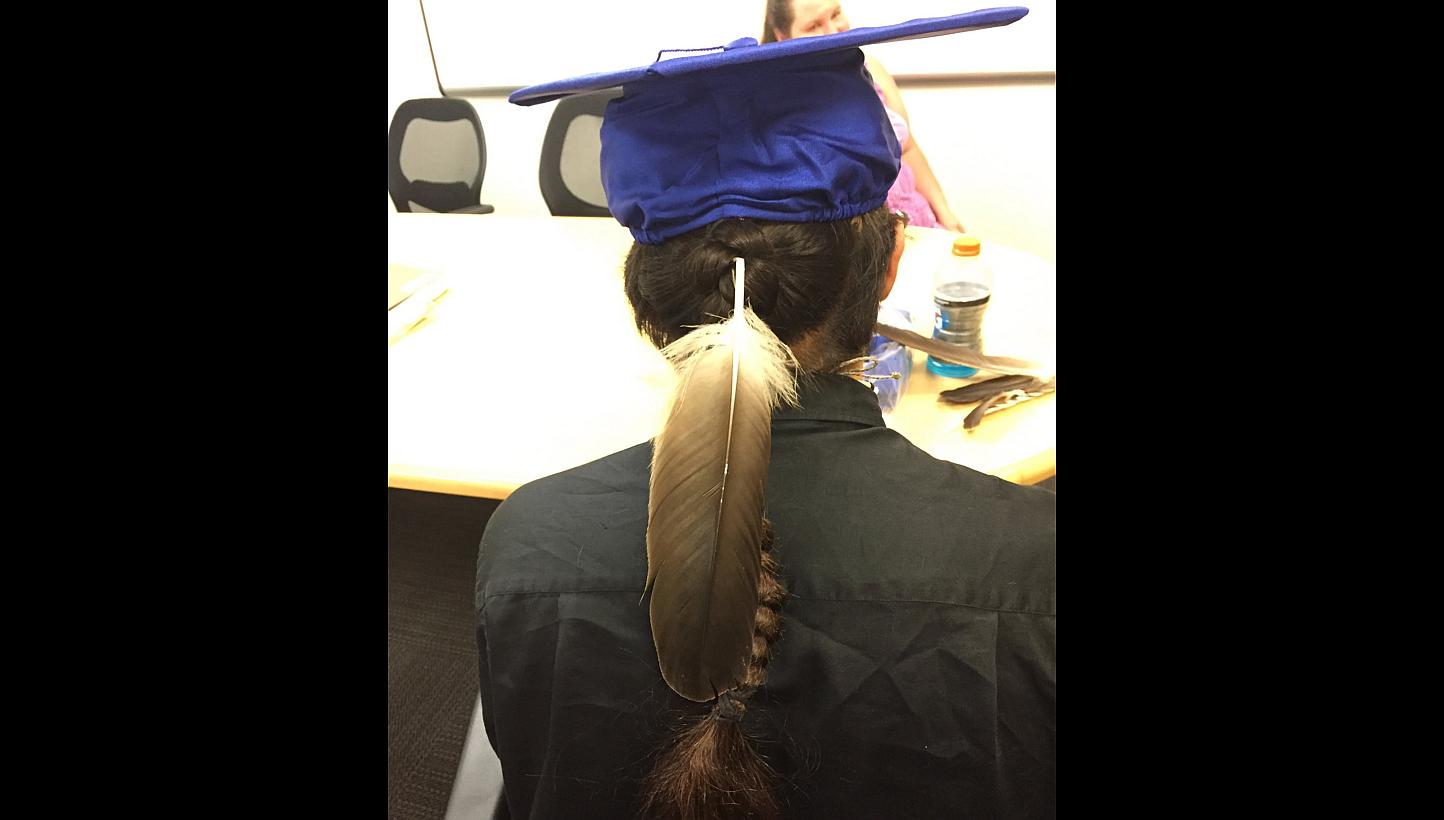 Christian Titman wearing his graduation cap and gown, along with a ceremonial eagle feather presented to him by his father in Fresno, California in this June 2, 2015 handout photo released to Reuters on June 3, 2015. -- PHOTO: REUTERS