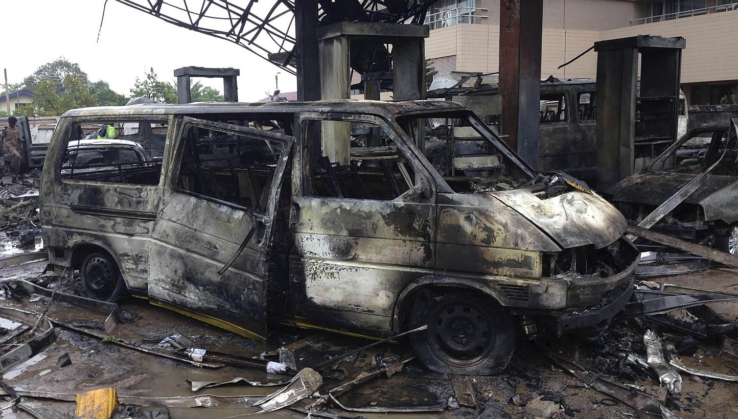 The charred wreckage of a minivan is seen at a gas station that exploded overnight killing around 90 people in Accra, Ghana, on June 4, 2015.&nbsp;An explosion at a petrol station in Ghana's capital killed about 90 people, many of whom had sought she