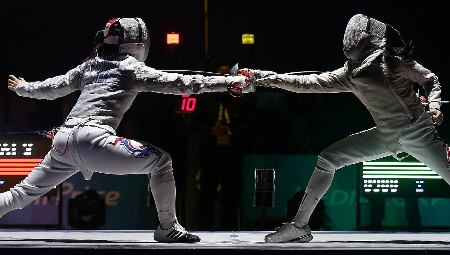 Thailand's Starrat Sirawalai (left) beats Singapore's Ywen Lau 15-13 in the SEA Games fencing women's individual sabre semifinals held at the OCBC Arena Hall 2 on June 4, 2015.&nbsp;The Singapore fencers ended their individual campaigns after winning